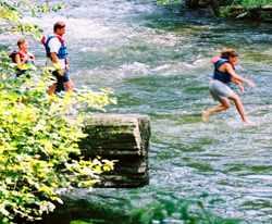 A family jumps off Picnic Rock